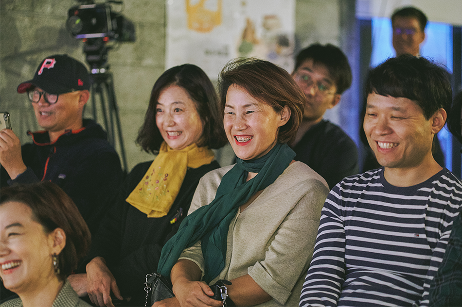 골목콘서트를 관람하며 미소짓는 관객들