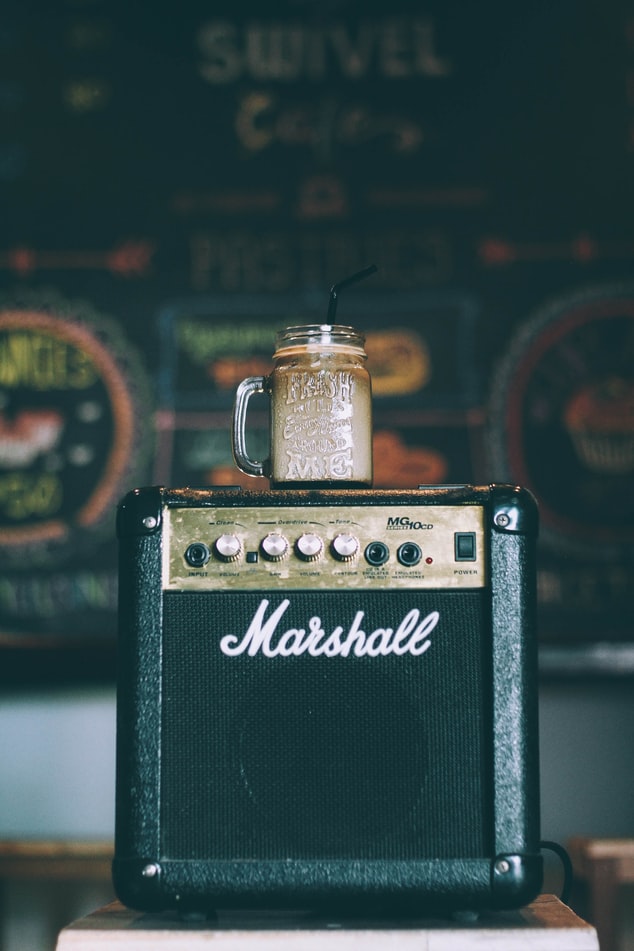 Marshall 스피커 위 라테가 가득 담긴 빨대 꽂힌 jar
