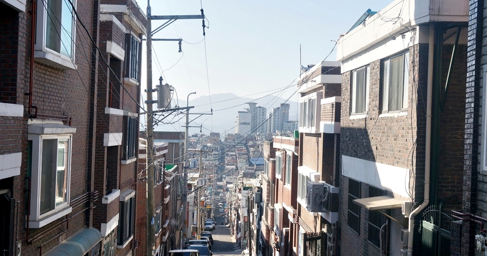 골목길 끝에 보이는 고층 아파트가 세월의 흐름을 보여준다. 