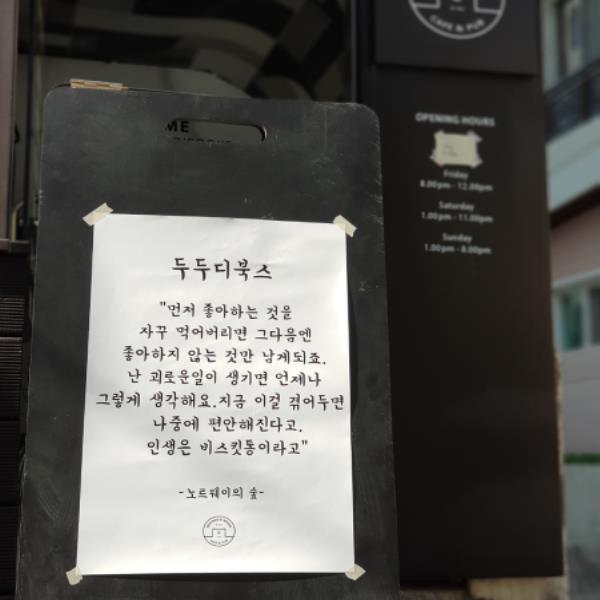 두두디북스 입구에 붙어있는 고전의 구절 "먼저 좋아하는 것을 자꾸 먹어버리면 그 다음엔 좋아하지 않는 것만 남게되죠. 난 괴로운일이 생기면 언제나 그렇게 생각해요. 지금 이걸 겪어두면 나중에 편안해진다고. 인생은 비스킷통이라고" - 노르웨이의 숲-