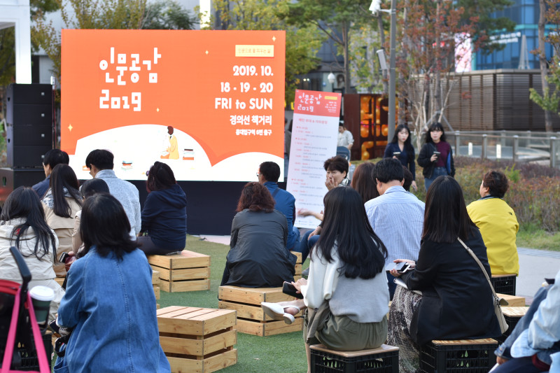 인문360 현장 사진 공연장에 모여 앉은 시민들 / 현수막 문구 : 인문공감 2019 2019.10 18-19-20 경의선 책거리 홍대입구역 8번 출구 