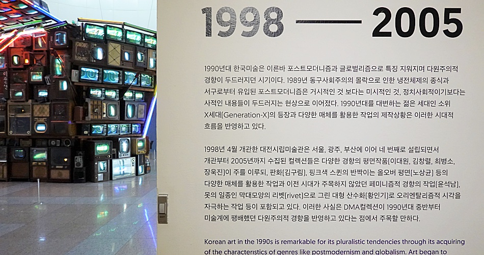 전시 내용에 대한 간략한 소개 : 1990년대 한국미술은 이른바 포스트모더니즘과 글로벌리즘으로 특징 지워지며 다원주의적 경향이 두드러지던 시기이다. 1989년 동구사회주의의 몰락으로 인한 냉전체제의 종식과 서구로부터 유입된 포스트모더니즘은 거시적인 것 보다는 미시적인 것, 정치사회적이기보다는 사적인 내용들이 두드러지는 현상으로 이어졌다. 1990년대를 대변하는 젊은 세대인 소위 X세대의 등장과 다양한 매체를 활용한 직업의 제작상황은 이러한 시대적 흐름을 반영하고 있다. 1998년 4월 개관한 대전시립미술관은 서울, 광주, 부산에 이어 네 번째로 설립되면서 개관부터 2005년까지 수집된 컬렉션들은 다양한 경향의 평면작품이 주를 이루되, 판화, 핑크색 스킨의 반짝이는 울오버 평면 등의 다양한 매체를 활용한 작업과 이전 시대가 주목하지 않았던 패미니즘적 경향의 작업, 못의 일종인 막대모양의 리벳으로 그린 대형 산수화로 오리엔탈리즘적 시각을 자극하는 작업 등이 포함되고 있다. 이러한 사실은 DMA컬렉션이 1990년대 중반부터 미술계에 팽배했던 다원주의적 경향을 반영하고 있다는 점에서 주목할 만하다.