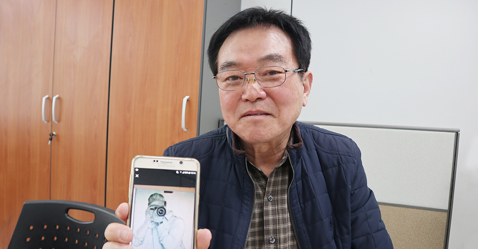 휴대폰 속 그림을 보여주는 송용준 씨