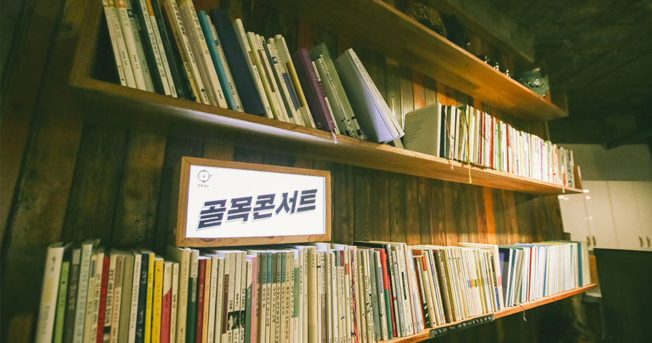 골목콘서트 라고 적힌 레터링 등을 책장에 두고 찍은 사진
