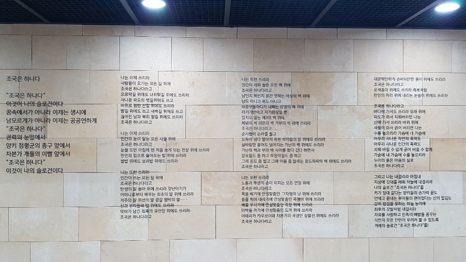   김남주     조국은 하나다 이것이 나의 슬로건이다 꿈 속에서가 아니라 이제는 생시에 남 모르게가 아니라 이제는 공공연하게 조국은 하나다 양키 점령군의 탱크 앞에서 자본과 권력의 총구 앞에서 조국은 하나다  이제 나는 쓰리라 사람들이 주고받는 모든 언어 위에 조국은 하나다 라고 탄생의 말 응아응아로부터 시작하여 죽음의 말 아이고아이고에 이르기까지 조국은 하나다 라고 갓난아기가 엄마로부터 배우는 최초의 말 엄마 엄마 위에도 쓰고 어린아이가 어른들로부터 배우는 최초의 행동 아장아장 걸음마 위에도 쓰리라 조국은 하나다 라고  나는 또한 쓰리라 사람들이 오고가는 모든 길 위에 조국은 하나다 라고 만나고 헤어지고 헤어지고 만나고 기쁨과 슬픔을 나눠 가지는 인간의 길 오르막길 위에도 쓰고 내리막길 위에도 쓰리라 조국은 하나다 라고 바위로 험한 산길 위에도 쓰고 파도로 사나운 뱃길 위에도 쓰고 끊어진 남과 북의 철길 위에도 쓰리라  오 조국이여 세상에서도 가장 아름다운 꽃이여 이름이여 나는 또한 쓰리라 인간의 눈길이 닿는 모든 사물 위에 조국은 하나다 라고 눈을 뜨면 아침에 당신이 맨 먼저 보게 되는 천정 위에도 쓰고 눈을 감으면 한밤에 맨 나중까지 떠 있는 샛별 위에도 쓰리라 조국은 하나다 라고 그리고 아침 저녁으로 축복처럼 만인의 배에서 차오르는 겨례의 양식이여 나는 쓰리라 쌀밥 위에도 쓰고 보리밥 위에도 쓰리라 조국은 하나다 라고  바다에 가서 쓰리라 모래 위에 조국은 하나다 라고 파도가 와서 지워 버리면 그 이름 산에 가서 쓰리라 바위 위에 조국은 하나다 라고 세월이 와서 지워 버리면 그 이름 가슴에 내 가슴에 수놓으리라 아무리 사나운 자연의 폭력도 아무리 사나운 인간의 폭력도 감히 어쩌지 못하도록 누이의 붉은 마음의 실로 조국은 하나다 라고 그리하여 마침내 나는 외치리라  인간이 세워놓은 모든 벽에 대고 조국은 하나다 라고 아메리카 카우보이와 자본가의 국경 삼팔선에 대고 외치리라 조국은 하나다 라고 식민지의 낮과 밤이 쌓아 올린 분단의 벽에 대고 나는 외치리라 조국은 하나다 라고 압제와 착취가 날조해낸 허위의 벽 반공 이데올로기에 대고 나는 외치리라 조국은 하나다 라고  그리하여 마침내 나는 내걸리라 지상에 깃대를 세워 하늘 높이에 나의 슬로건 조국은 하나다를 키가 장대 같다는 양키의 손가락 끝도 가난의 등에 주춧돌을 올려 놓고 그 위에 거재를 쌓아 올린 부자들의 빌딩도 언제고 끝내는 가진 자들의 형제였던 교회의 첨탑도 감히 범접을 못하도록 최후의 깃발처럼 내걸리라 자유를 사랑하고 민중의 해방을 꿈꾸는 식민지 모든 인민이 우러러볼 수 있도록 남과 북의 슬로건 조국은 하나다를!